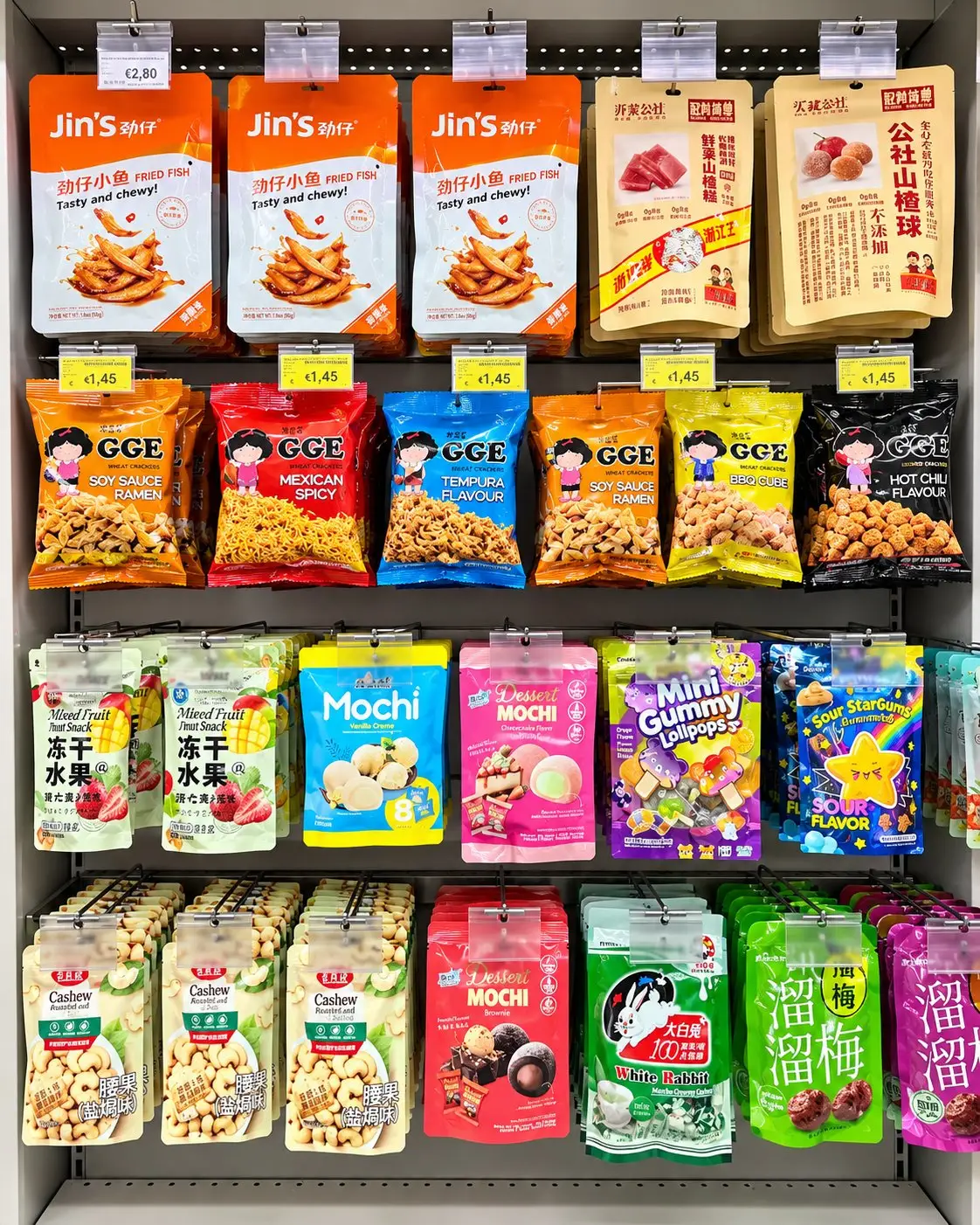 Scaffale di snack asiatici appesi: patatine, mochi e caramelle gommose